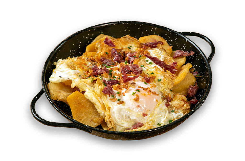 Huevos rotos con patatas, jamón ibérico y cebolla crujiente