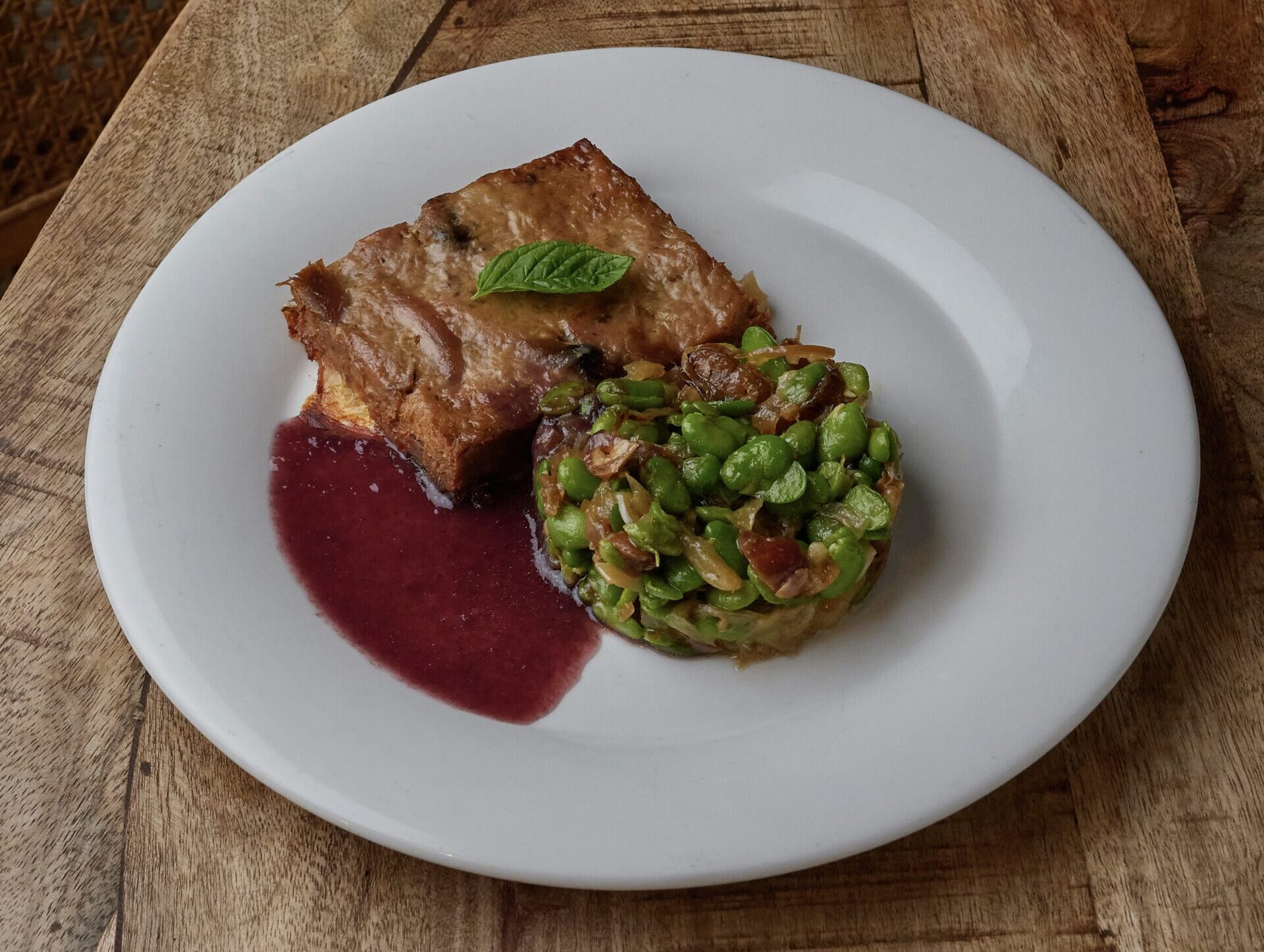 Cordero a la brasa con habitas tiernas y dátiles, jugo reducido de uva (mosto)